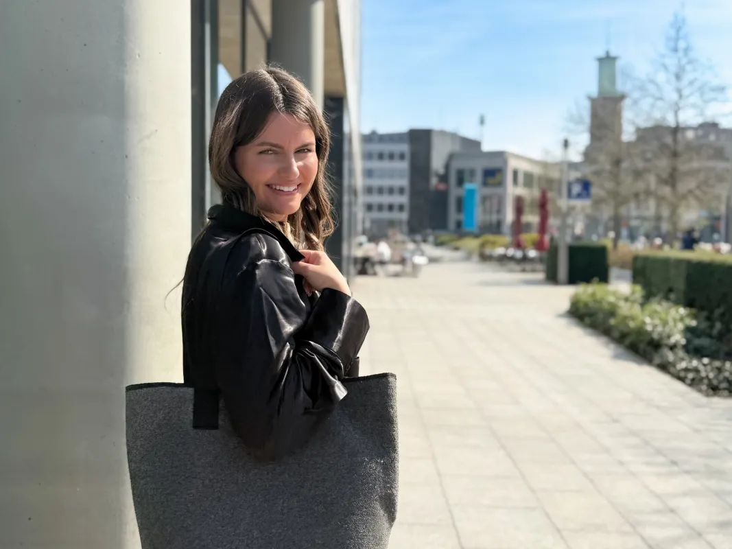 Junge Mitarbeiterin vor dem Sparkassengebäude